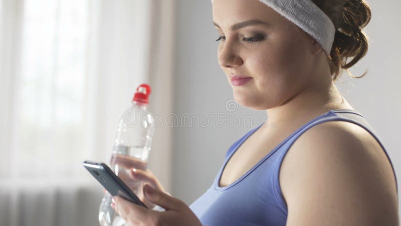 Sports woman scrolling her smartphone looking for new ways of weight loss