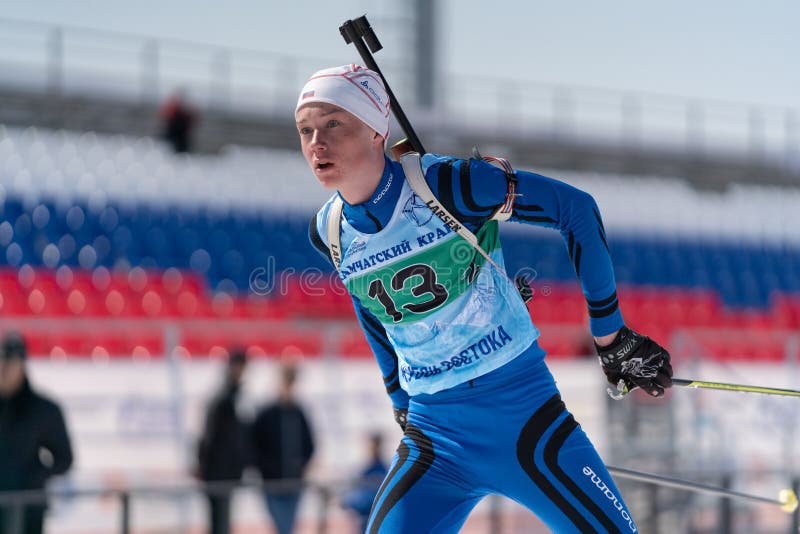 Sportsman biathlete Protasov Dmitry sci su pista da sci biathlon arena durante le gare junior di biathlon East fotografia stock libera da diritti Sportsman biathlete Protasov Dmitry sci su pista da sci biathlon arena durante le gare junior di biathlon East fotografia stock libera da diritti