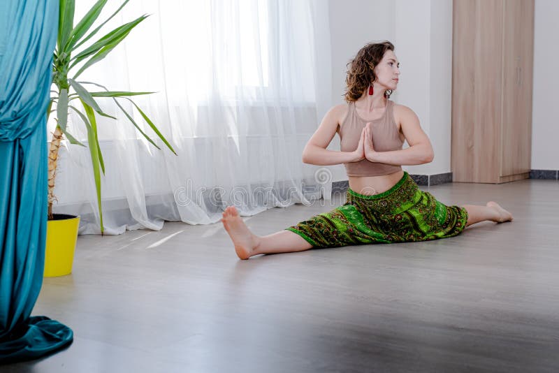 Sportswoman hanging in a hammock in an inverted position on a white window background. Space for text stock image