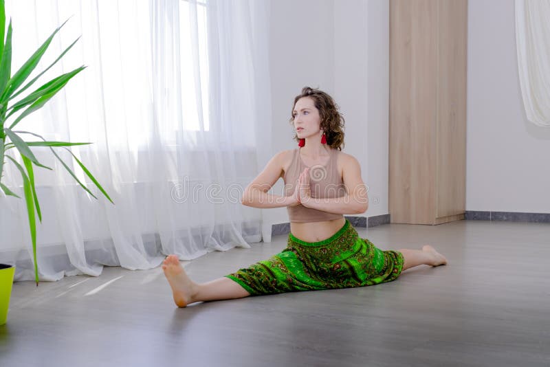 Sportswoman hanging in a hammock in an inverted position on a white window background. Space for text royalty free stock images