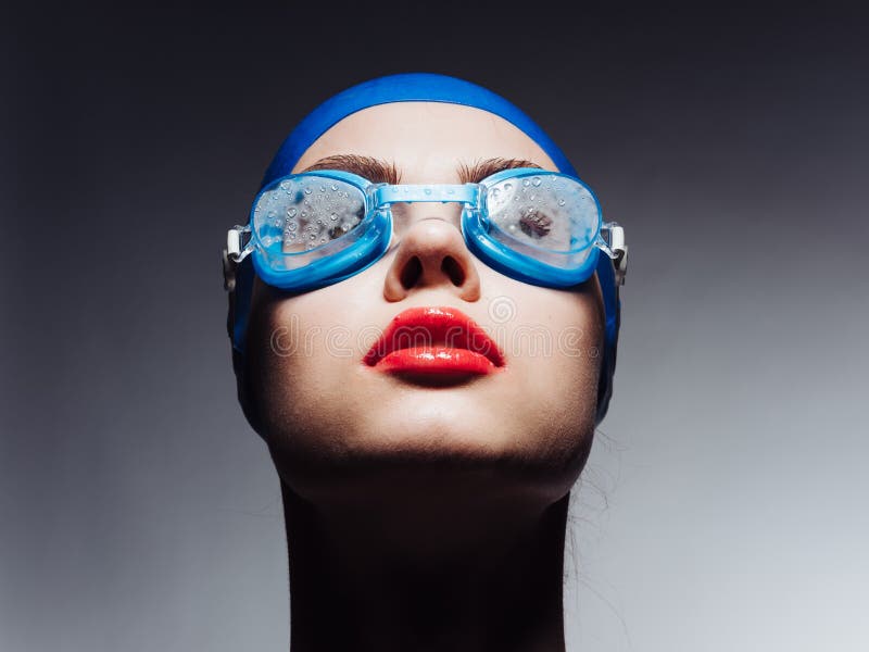 Sportswoman With Red Lips In Blue Swimming Cap And Glasses Looking Up