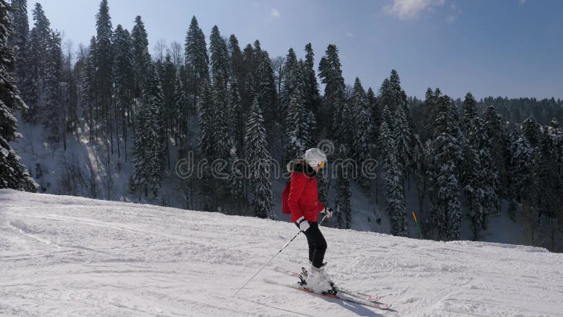 Sportvrouw skier skiën op skipistresort op zonnige winterdag