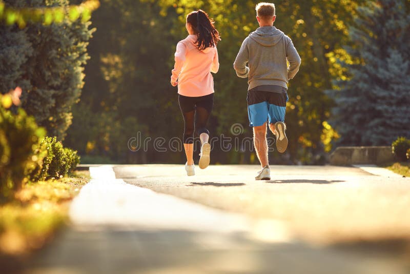 Sporty couple are running along the city street in the morning. stock photography Sporty couple are running along the city street in the morning. stock photography
