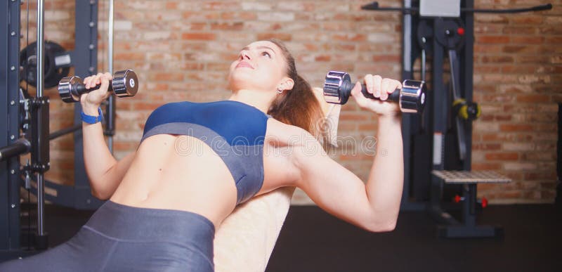 Sporty Girl doing dumbbell press