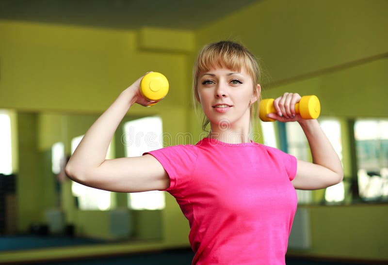 Sporty girl doing exercise with dumbbells stock photo