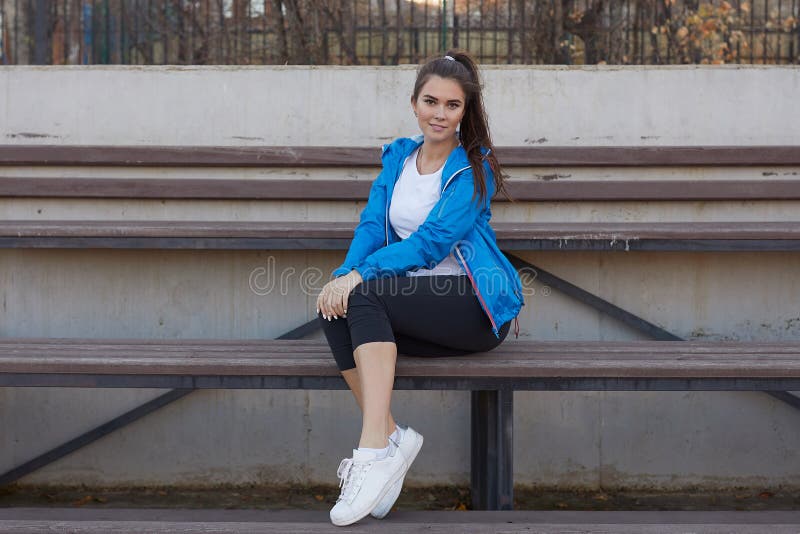 Sporty girl on the stadium. Stadium tribune. Slim sporty fitness woman.