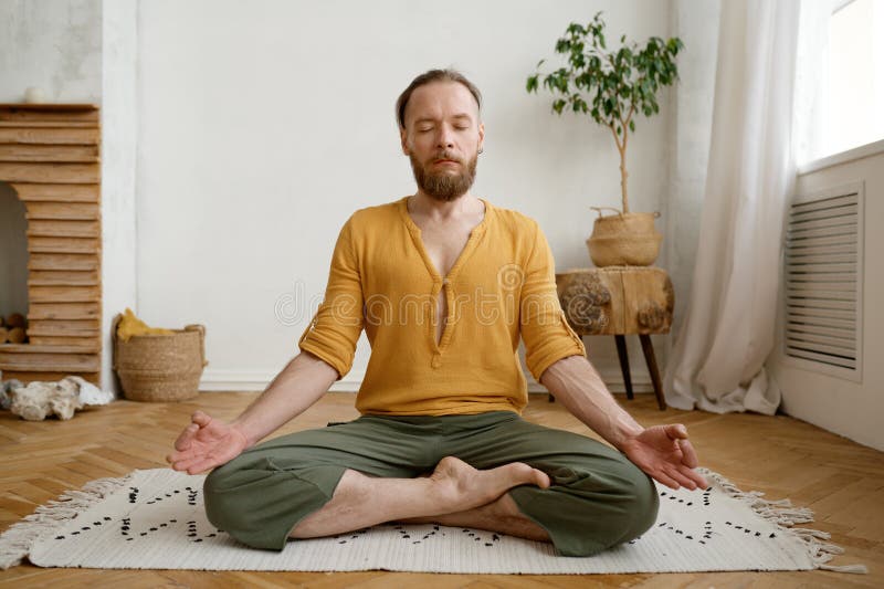 Sporty mindful man meditating alone at home apartment royalty free stock photography