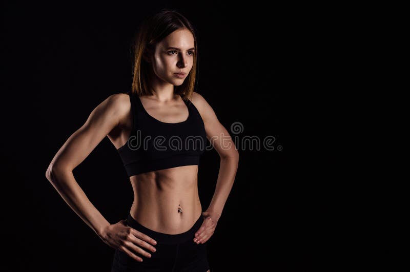 Foto de Beautiful athletic woman with long hair posing. Fitness girl  showing muscular athletic body, abs. Isolated on white do Stock
