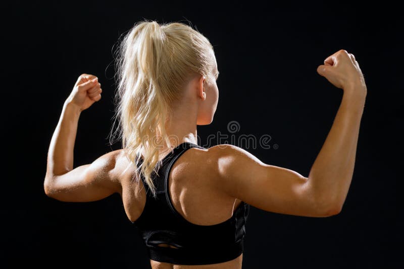 Fitness, sport and diet concept - sporty woman form the back flexing her biceps. Fitness, sport and diet concept - sporty woman form the back flexing her biceps.