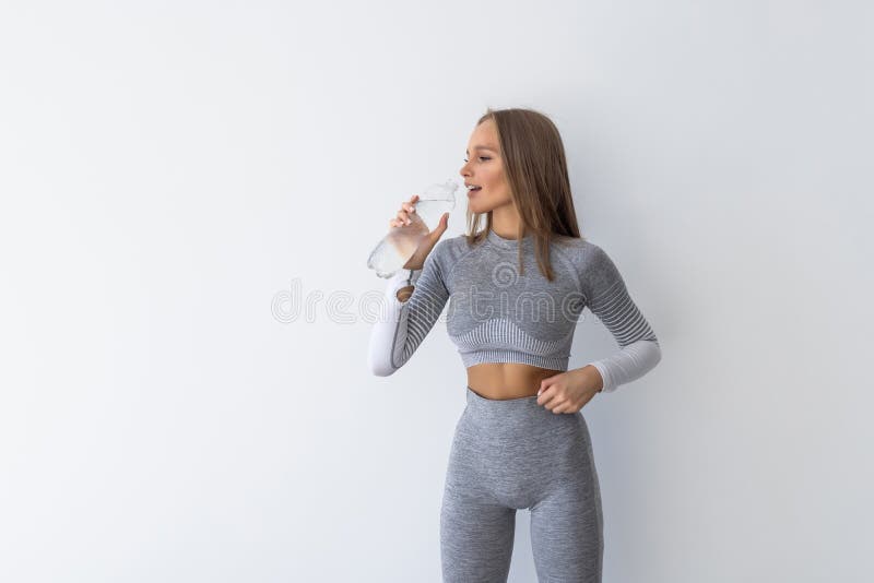 Sporty woman drink water from bottle, isolated on white background