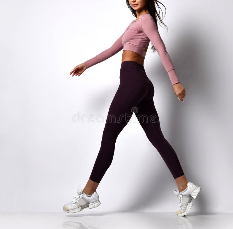 Sporty woman legs walking in sport wear on a white background