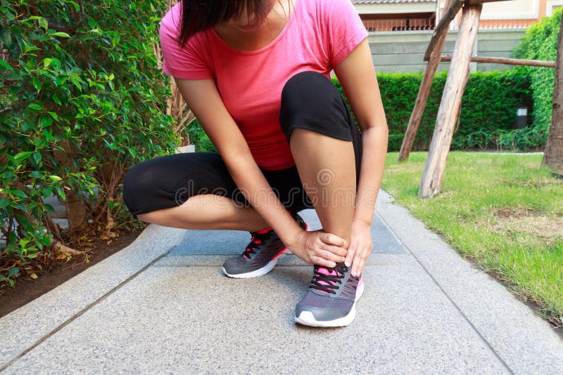 Asian Sporty Woman Ankle Sprain while Jogging or Running Stock Image