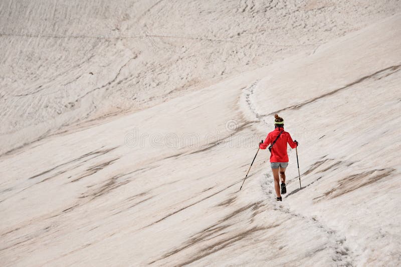 Sporty woman walk down on the dirty snow on the Tahtali mountain with hiking sticks stock photo Sporty woman walk down on the dirty snow on the Tahtali mountain with hiking sticks stock photo