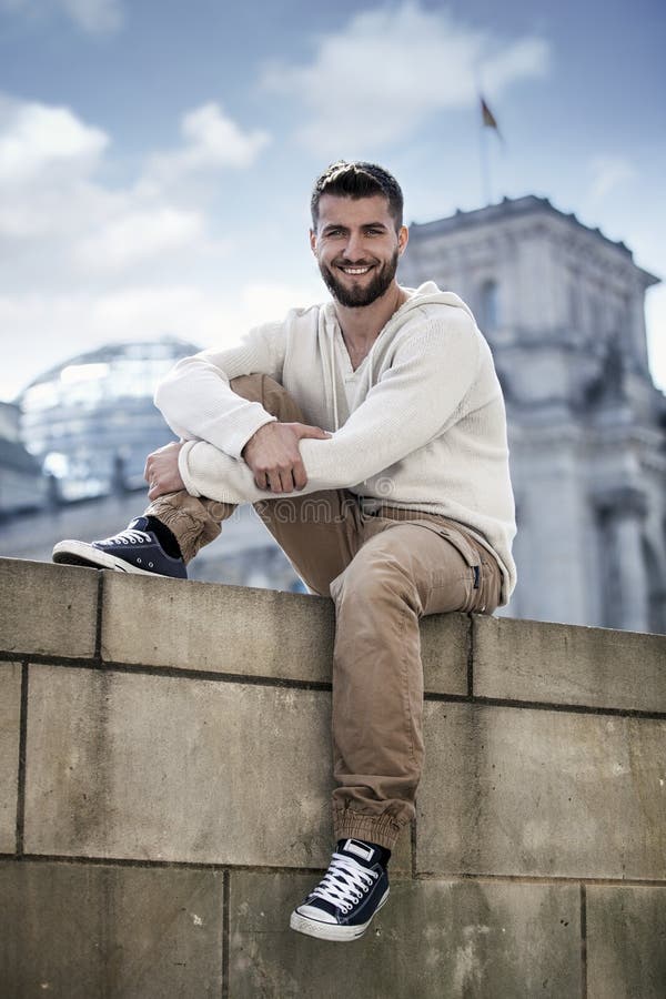 Sporty Young Man Sitting on a Wall Stock Photo - Image of business ...