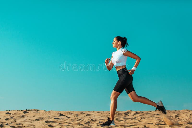 Sporty young woman and fit athlete runner running on the sky background. The concept of a healthy lifestyle and sport