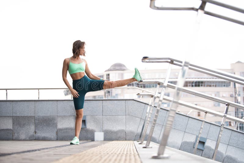 Woman Runner Stretching Leg Muscle Before Running Outdoors For Athlete