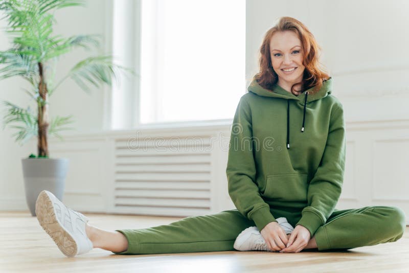 Sporty мотивированная женщина демонстрирует славную гибкость, тонкое тело, протягивает ноги, имеет тренировки pilates фитнеса, но стоковые фото Sporty мотивированная женщина демонстрирует славную гибкость, тонкое тело, протягивает ноги, имеет тренировки pilates фитнеса, но стоковые фото