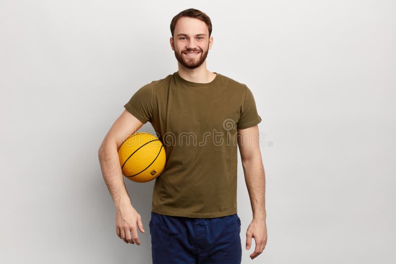 Sporty положительный спортсмен с шариком смотря камеру стоковая фотография rf Sporty положительный спортсмен с шариком смотря камеру стоковая фотография rf