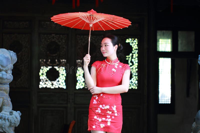 Sposa cinese felice nel cheongsam rosso al giorno delle nozze tradizionale fotografia stock Sposa cinese felice nel cheongsam rosso al giorno delle nozze tradizionale fotografia stock