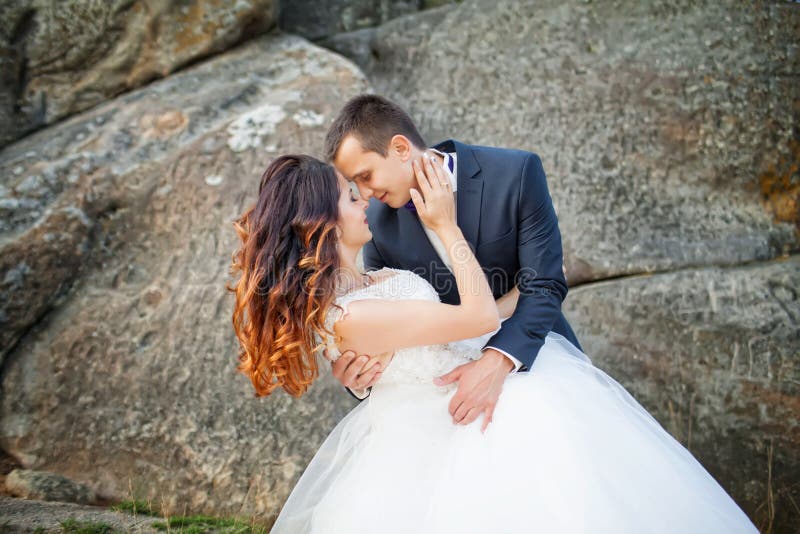 Sposa e sposo al giorno delle nozze che abbraccia all'aperto sulla natura della molla fotografia stock libera da diritti Sposa e sposo al giorno delle nozze che abbraccia all'aperto sulla natura della molla fotografia stock libera da diritti