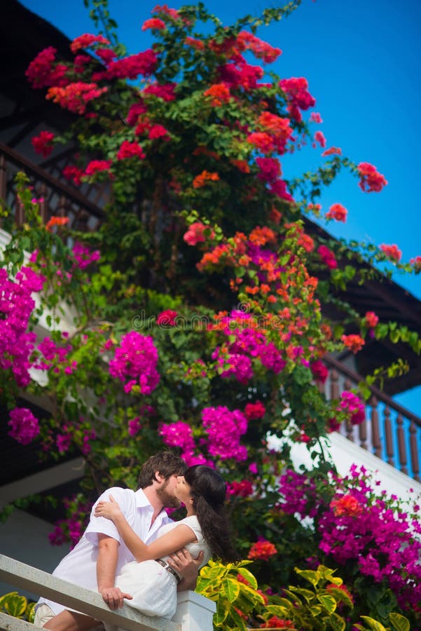 Sposa e sposo che baciano sul balcone immagini stock Sposa e sposo che baciano sul balcone immagini stock