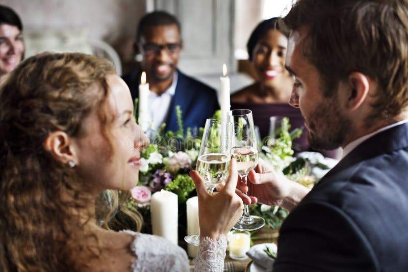 Sposa e sposo Clinging Wineglasses Together a nozze Recepti immagine stock libera da diritti