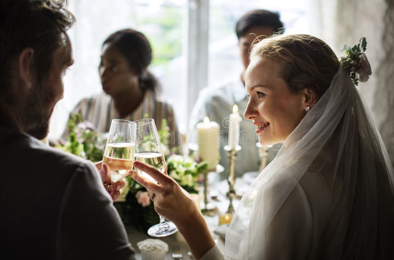 Sposa e sposo Clinging Wineglasses Together a nozze Recepti immagini stock libere da diritti