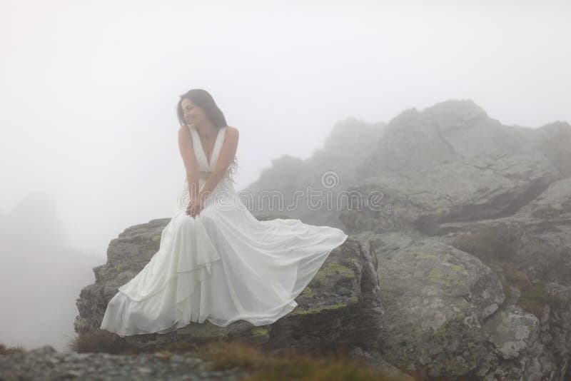 Sposa misteriosa che si siede sulla cima della montagna rocciosa fotografia stock libera da diritti Sposa misteriosa che si siede sulla cima della montagna rocciosa fotografia stock libera da diritti