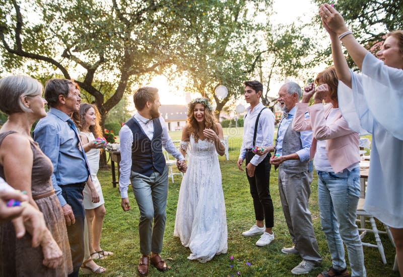 Sposa, sposo ed ospiti al ricevimento nuziale fuori nel cortile