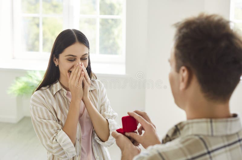 Sposami proponendo all'uomo che tiene in mano una scatola rossa con una proposta di preparazione per l'anello di fidanzamento fotografie stock libere da diritti