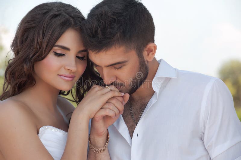 Sposo in mano bianca della sposa di bacio della camicia Molto delicato immagine stock Sposo in mano bianca della sposa di bacio della camicia Molto delicato immagine stock