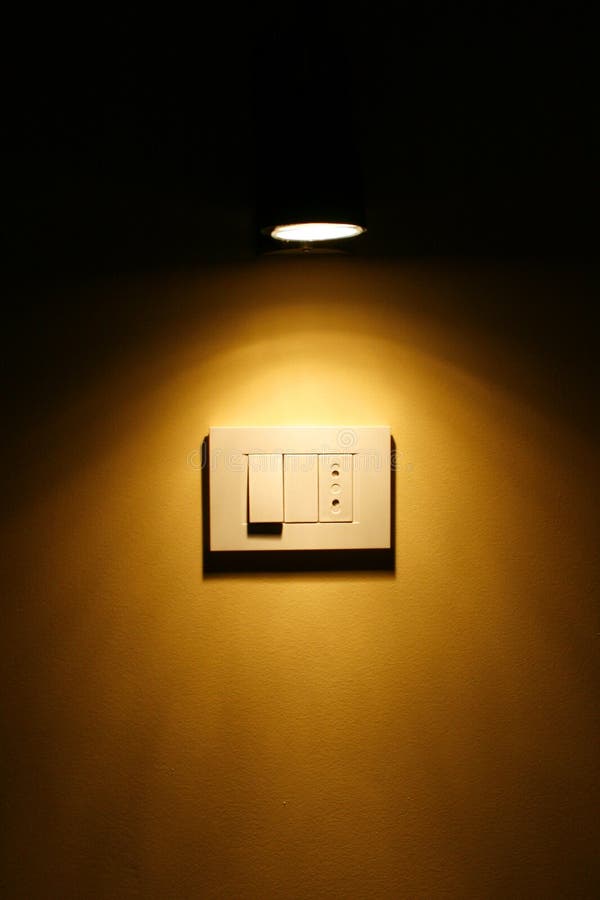 Spotlight Above Dark Yellow Wall Outlet and Switch Stock Photo Image