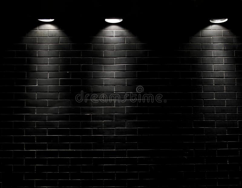 Spotlights on a black brick wall