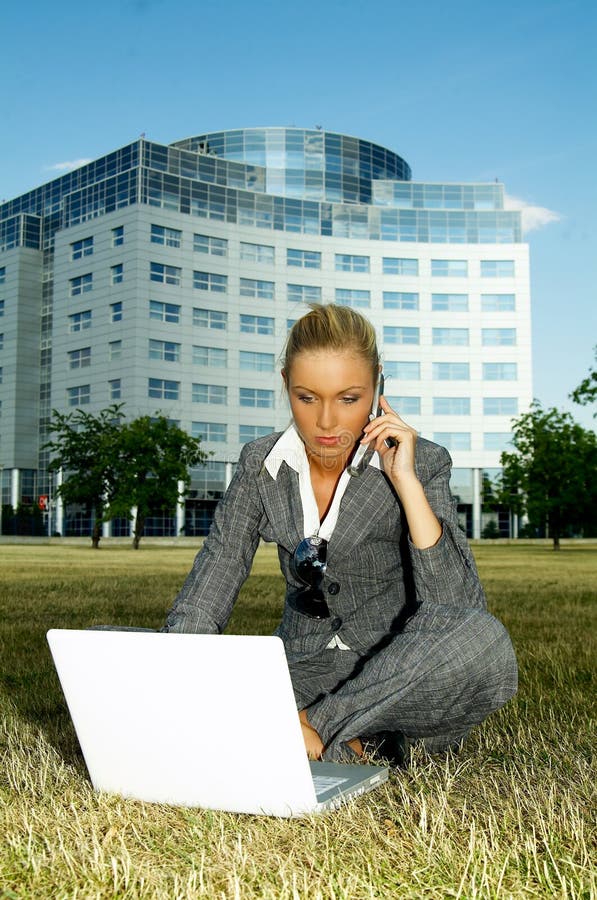 Business woman working on grass with laptop computer. Business woman working on grass with laptop computer