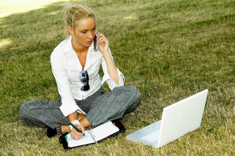 Business woman working on grass with laptop computer. Business woman working on grass with laptop computer