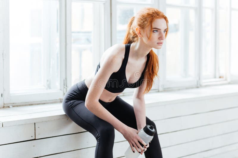 Sprawności fizycznej dziewczyny mienia odpoczynkowy bidon przy gym obrazy stock Sprawności fizycznej dziewczyny mienia odpoczynkowy bidon przy gym obrazy stock