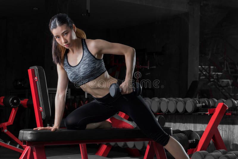 Sprawności fizycznej kobieta, Azjatycka sportowa kobieta pompuje up mięśnie z dumbbells zdjęcie royalty free Sprawności fizycznej kobieta, Azjatycka sportowa kobieta pompuje up mięśnie z dumbbells zdjęcie royalty free