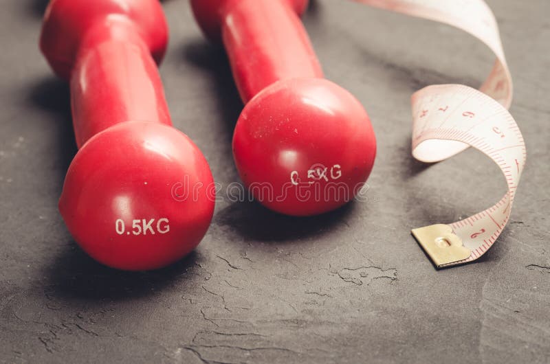 sprawności fizycznej pojęcie z czerwonymi dumbbells, pomiarowy tape/sprawności fizycznej pojęcie z czerwonymi dumbbells i pomiaro zdjęcie royalty free sprawności fizycznej pojęcie z czerwonymi dumbbells, pomiarowy tape/sprawności fizycznej pojęcie z czerwonymi dumbbells i pomiaro zdjęcie royalty free