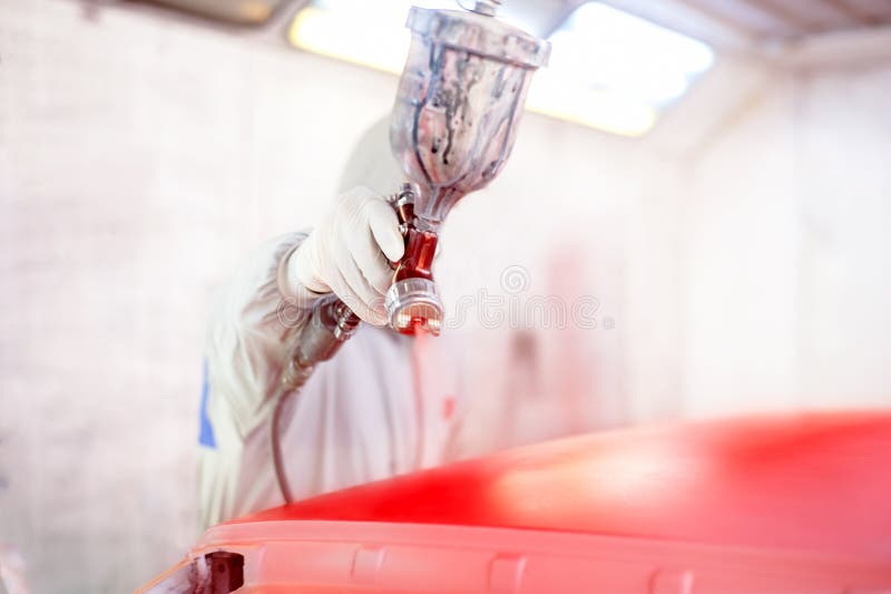 Worker Painting a Red Car in Painting Booth Using Spray Gun Stock Image