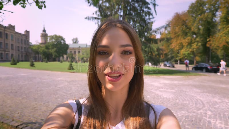 Spreekt de jonge vrouw van Nice in videochat in park in dag, die camera, communicatie concept houden