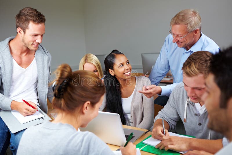 Teacher helping college students in study class. Teacher helping college students in study class