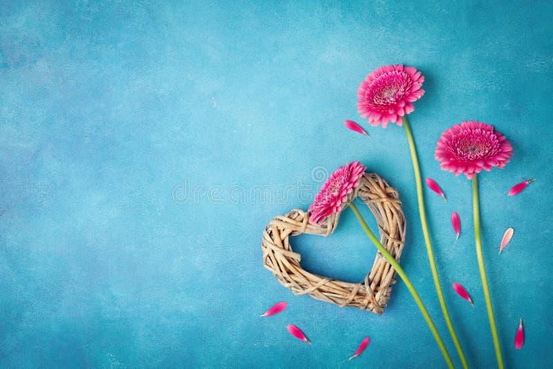 Spring background with pink flowers, heart and petals. Greeting card for Woman day. Flat lay style. Top view.