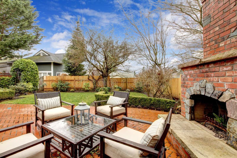 Spring backyard with outdoor fireplace and furniture.