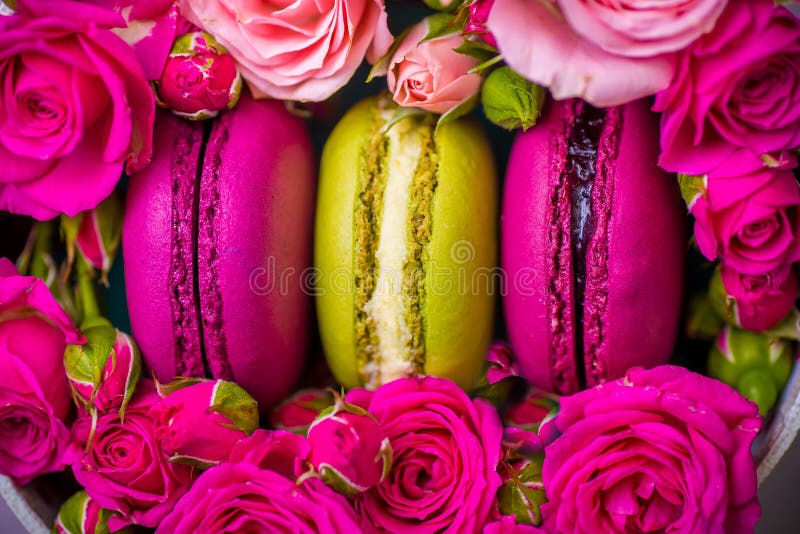 Spring berry color macaroons with roses background with love