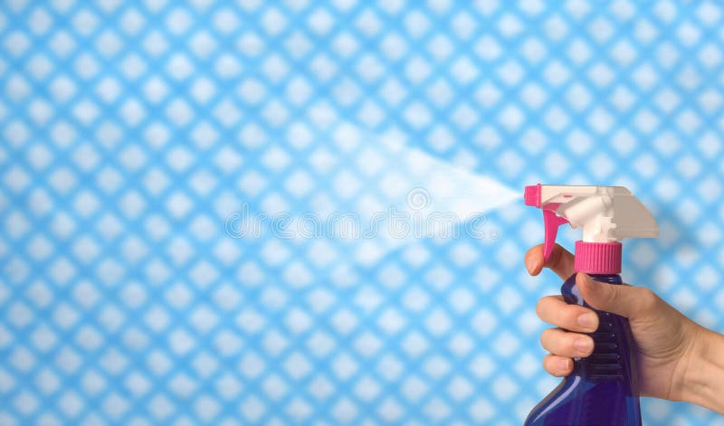 Una mujer mano rociar limpieza brillar través de tela.