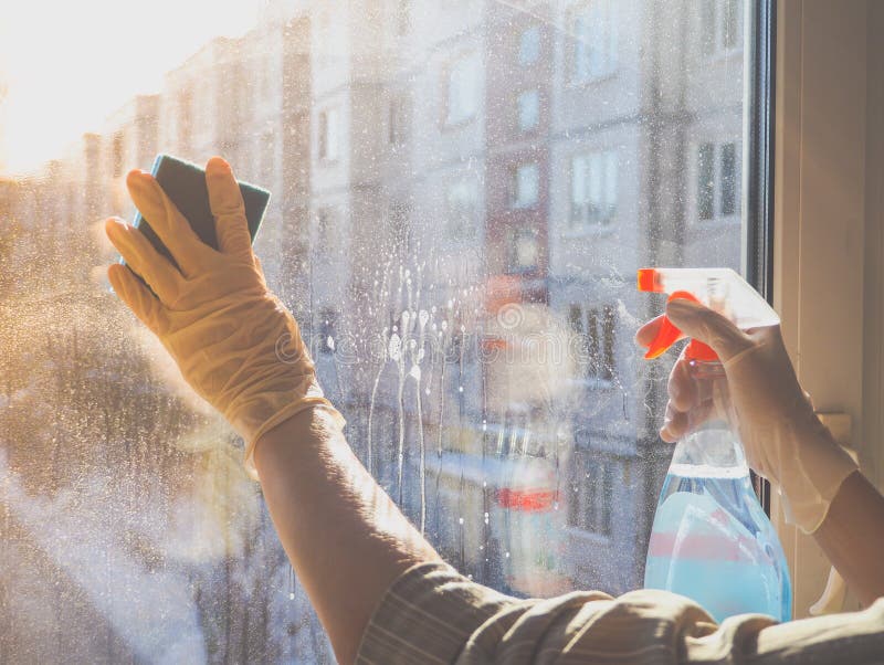 Spring cleaning - cleaning windows. Women`s hands wash the window, cleaning