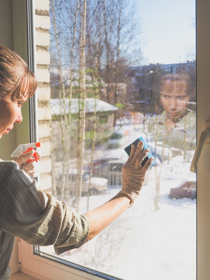 Spring cleaning - cleaning windows. Women`s hands wash the window, cleaning