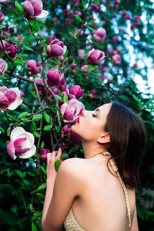 Spring fashion concept. Fashion spring girl on Spring Magnolia flowers background. Woman on Spring blossom background.