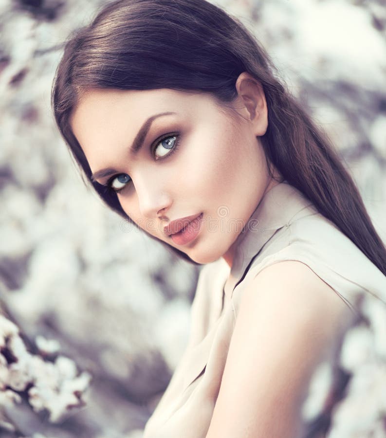 Spring fashion girl outdoors in blooming trees