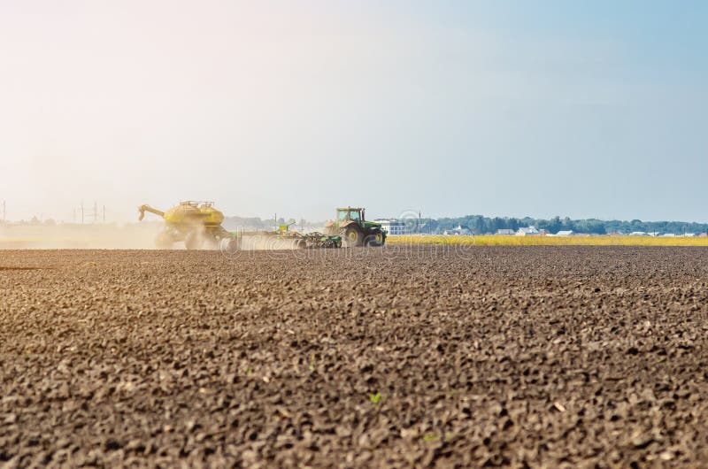 Spring Field Work. Tractor Plows the Ground in the Field. Editorial